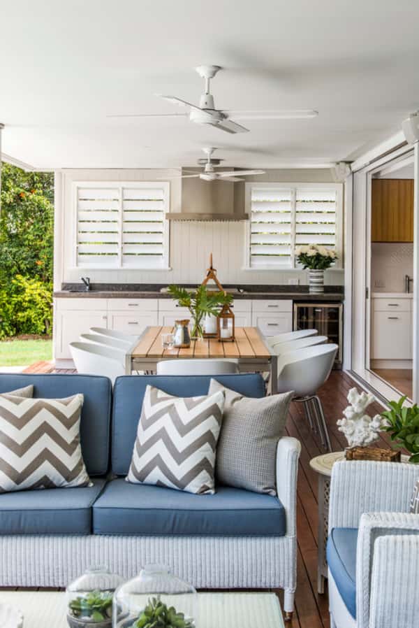 Large patio with outdoor kitchen, sitting area, and dining area. Two separate white Polywood shutter windows are located above the kitchen counter.